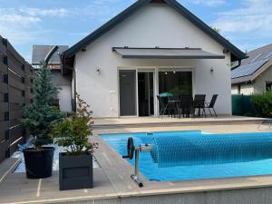 a home with a swimming pool in front of a house at RoyalHill Apartman in Vonyarcvashegy