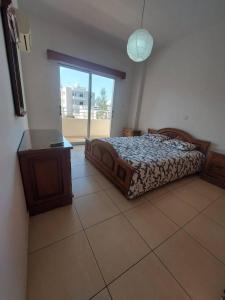 a bedroom with a bed and a table and a window at Sunny 2 Bedroom Larnaca Center in Larnaka