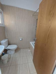 a bathroom with a toilet and a sink and a door at Sunny 2 Bedroom Larnaca Center in Larnaka