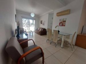 a living room with a table and a couch at Sunny 2 Bedroom Larnaca Center in Larnaka