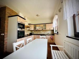 a kitchen with a white table and chairs at Chata Odeta in Valtice