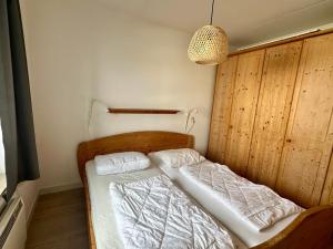 a bedroom with two beds in a room with a lamp at Appartement Badhotel 325 in Callantsoog