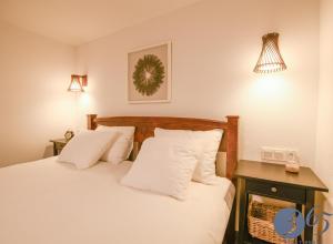 um quarto com uma cama com lençóis brancos e almofadas em 365 Guest House em Hunedoara