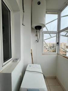 ein weißes Zimmer mit einem Fenster und einer Bank in der Unterkunft Coralia Haut Standing Appart f2 in Oujda