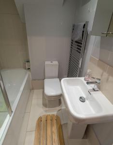 a bathroom with a sink and a toilet and a tub at Chalet Thirteen in Deal