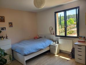 une chambre avec un lit avec une couette bleue et une fenêtre dans l'établissement SUPERBE MAISON FAMILIALE AVEC PISCINE, à Cabriès 36 autres photos