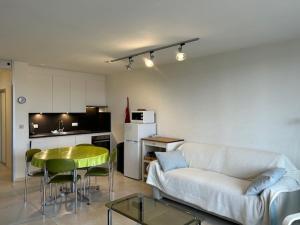 a living room with a couch and a table and a kitchen at Malgré Tout 0207 in Koksijde