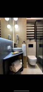 a bathroom with a sink and a toilet and lights at REMAR - Apartamenty z widokiem na Jezioro Biale in Augustów