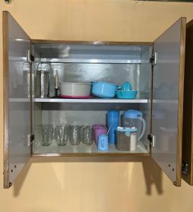 a cupboard with some pots and pans in it at Magnolia Departamento/Apartment in Barrio Esteban Echeverría +12 photos