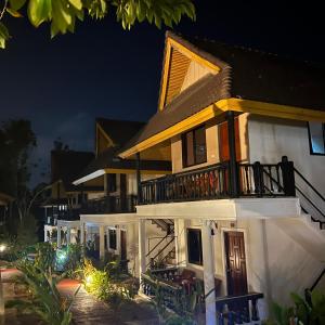 a large house with a balcony at night at Kata Villa Merit Hill Bungalows in Ka Rorn