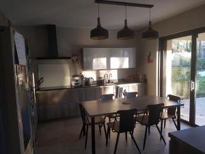 une cuisine avec une table et des chaises et une table et une cuisine dans l'établissement SUPERBE MAISON FAMILIALE AVEC PISCINE, à Cabriès