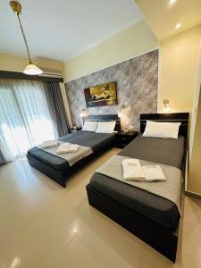 um quarto de hotel com duas camas e uma janela em Afrodite Seaside Rooms em Kallithea Halkidikis