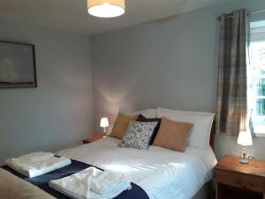 a bedroom with a white bed with pillows on it at The Coach House at Lowbyer in Alston