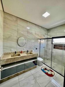 uma casa de banho com um chuveiro, um lavatório e um WC. em Casa Alto Padrão Represa de Itupararanga Ibíuna em Sorocaba