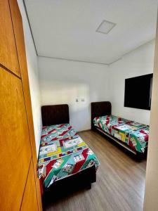 um quarto com 2 camas e uma televisão de ecrã plano em Casa Alto Padrão Represa de Itupararanga Ibíuna em Sorocaba