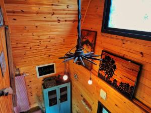 ventilatore a soffitto in camera con pareti in legno di Cabana/Sítio em meio a Natureza Chalé da Collina a Sertão