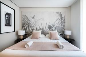 een slaapkamer met een groot bed met roze kussens bij YOU & CO. J. Botánico Boutique in Valencia