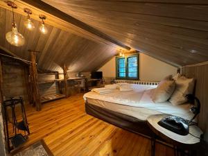 Villa Rila Borovets Mountain & Luxury with Hot Jacuzzi & Sauna في بوروفتس: غرفة نوم بسرير كبير في العلية