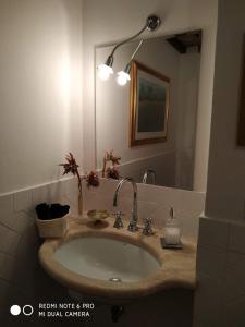 a bathroom with a sink and a mirror at Dimora Montebello in Pitigliano