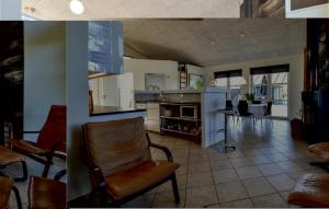a kitchen and a living room with a chair at Holiday Home Strandparken Otterup Vi in Otterup