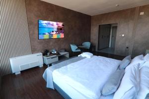 ネゴティノにあるGrey Star Hotelの大きなベッドとデスクが備わるホテルルームです。