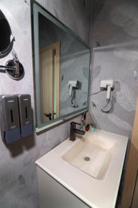 a bathroom with a sink and a mirror at Grey Star Hotel in Negotino