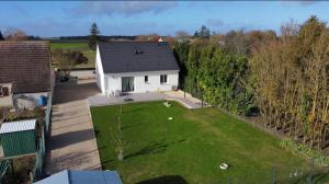 an aerial view of a white house with a yard at Petite maison au calme in Poupry