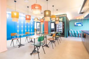un restaurant avec des tables et des chaises et des murs bleus dans l'établissement KLEY REIMS, à Reims