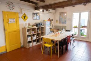 a kitchen with a table and chairs and a yellow door at Hostel Il Nosadillo - Bologna in Bologna