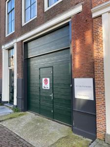 a green garage door on a brick building at Boutique Hotel De Vier Patriciërs in Middelburg