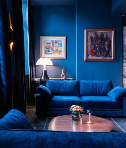 a blue living room with a blue couch and a table at Juliana Hotel Brussels in Brussels