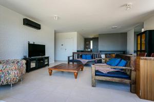 a living room with couches and a flat screen tv at Apto cobertura com vista p/ mar, Floripa ASR304 in Florianópolis