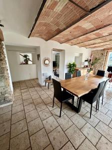 a dining room with a wooden table and chairs at Le Mas Jubilé in Mons +6 photos