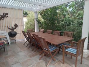 una mesa de madera y sillas en un patio en Dressage B&B, en Ciudad del Cabo
