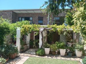 un jardín frente a un edificio de ladrillo con macetas en Dressage B&B, en Ciudad del Cabo