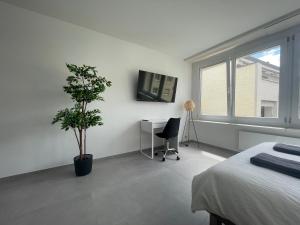 a bedroom with a bed and a desk and a window at H95 Studios in Basel City with Basel Card in Basel