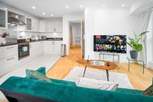 uma sala de estar com um sofá verde e uma mesa em Luxury 2 Bed City Centre - Secure Parking - Balconies - 1109M em Birmingham