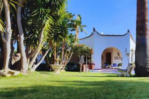 uma casa branca com palmeiras no quintal em Villa Alfonsa, Fontane Bianche, Siracusa, PRIVATE POOL, 10min from the beach em Fontane Bianche