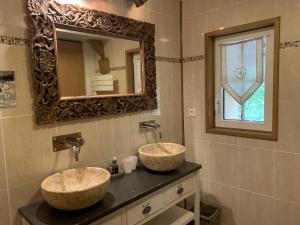 a bathroom with two sinks and a mirror at Gîte 3 étoiles Le Clos des Tilleuls in La Vendelée