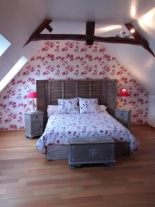 1 dormitorio con 1 cama con flores en la pared en Gîte 3 étoiles Le Clos des Tilleuls, en La Vendelée