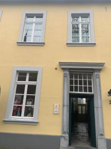 un edificio amarillo con dos ventanas y una puerta en Altes Forstamt, en Xanten