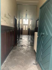 an empty hallway with a green door in a house at Altes Forstamt in Xanten