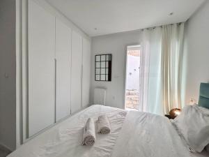 a child laying on a white bed with towels on it at Green Cocoon in Sidi Bou Saïd