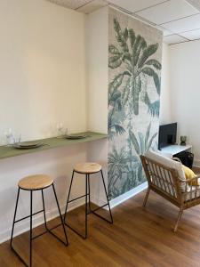 una habitación con 2 taburetes y una pared con un mural en Studio Malo les bains plage 3eme étage en Dunkerque