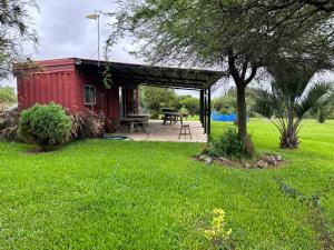 un cobertizo rojo con una mesa de picnic en un patio en Casa roja, en Fray Bentos