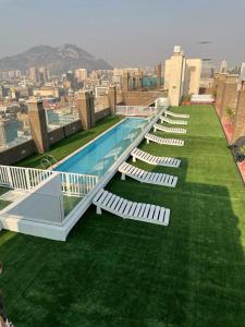 a pool on the roof of a building with chairs at Acuña & Donoso Apartamentos Centro in Santiago