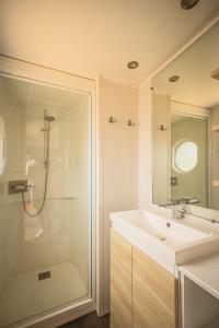 a white bathroom with a shower and a sink at Sauvage in Quiberon