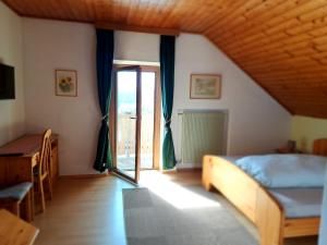 a bedroom with a bed and a sliding glass door at Webergütl in Auna di Sopra