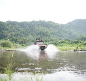 a jeep driving across a river in the water at Java Turtle Lodge Meru Betiri in Banyuwangi