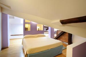 a bedroom with a bed in a room with purple walls at SM Hospitality SANTO STEFANO in Reggio Emilia